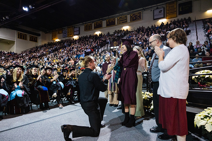 A CMU student receives a marriage proposal near the stage as her family stands nearby clapping. And yes, she said yes.
