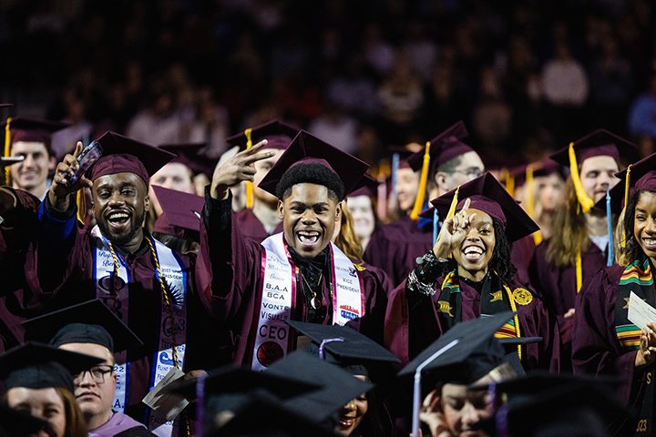 A group of CMU graduates smile for the camera.