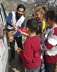 A man hands out supplies to earthquake victims.