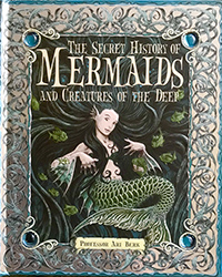 A cartoon mermaid with a green tail sits on the cover of 