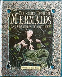 A cartoon mermaid with a green tail sits on the cover of