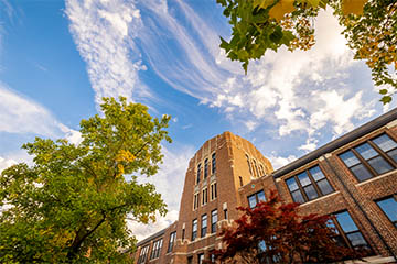CMU's Warriner Hall in the fall with wispy clouds above.