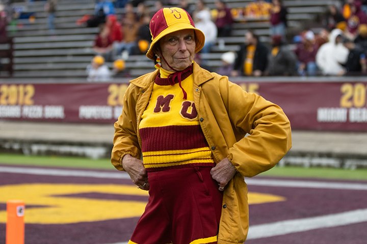 A CMU alum wears a vintage cheerleading outfit from the 1960s poses for the camera.