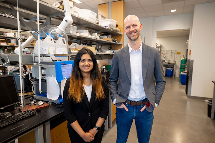 Goldwater Scholar Izzy Gaidhane with her faculty mentor, Ben Swarts as they stand in a lab.