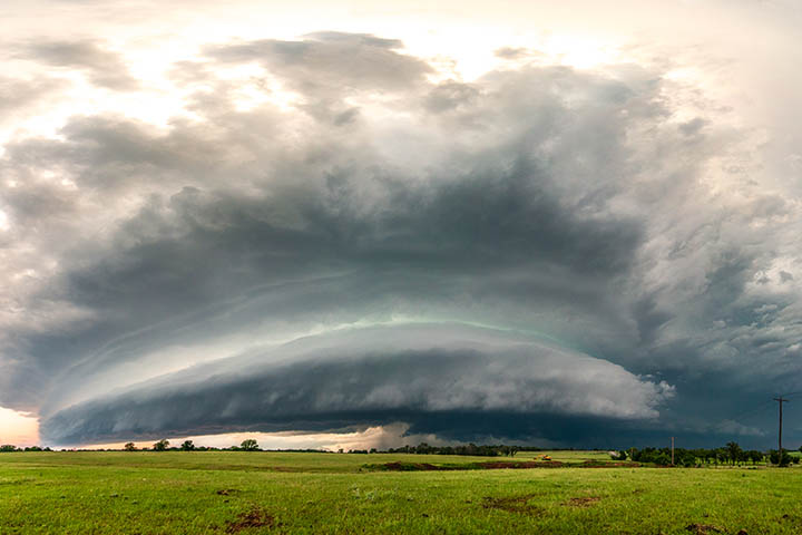 A hail-producing thunderstorm moves across a flat landscape.