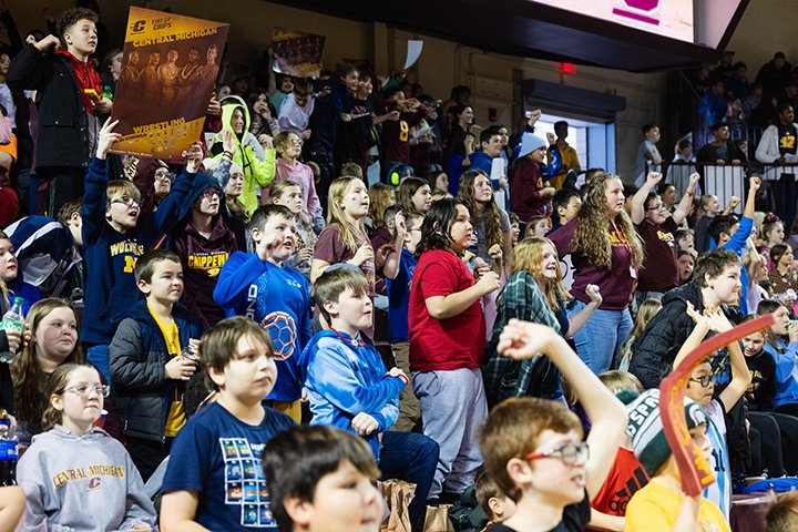 Hundreds of elementary students cheer from the stands inside McGuirk Arena.