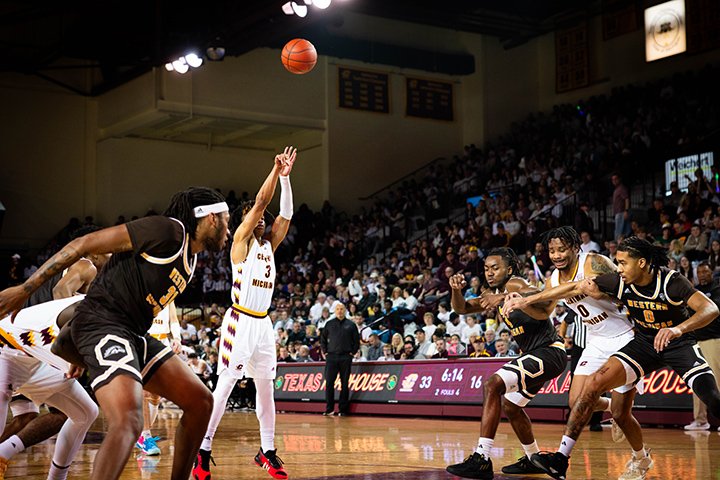 A CMU men's basketball player attempts a free throw as players from CMU and Western Michigan box each other out waiting for a potential rebound.