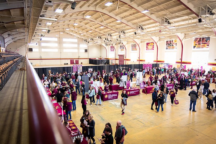 A wide-angle view of Finch Fieldhouse where hundreds of prospective students, family members and CMU faculty and staff meet during a Fired Up Friday event.