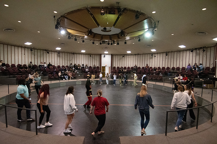 Students perform an Arab dance inside THe Townsend Kiva, which is a large, round room.