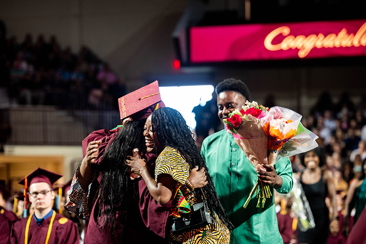 At CMU spring commencement, a graduate gets a hug from her family members.