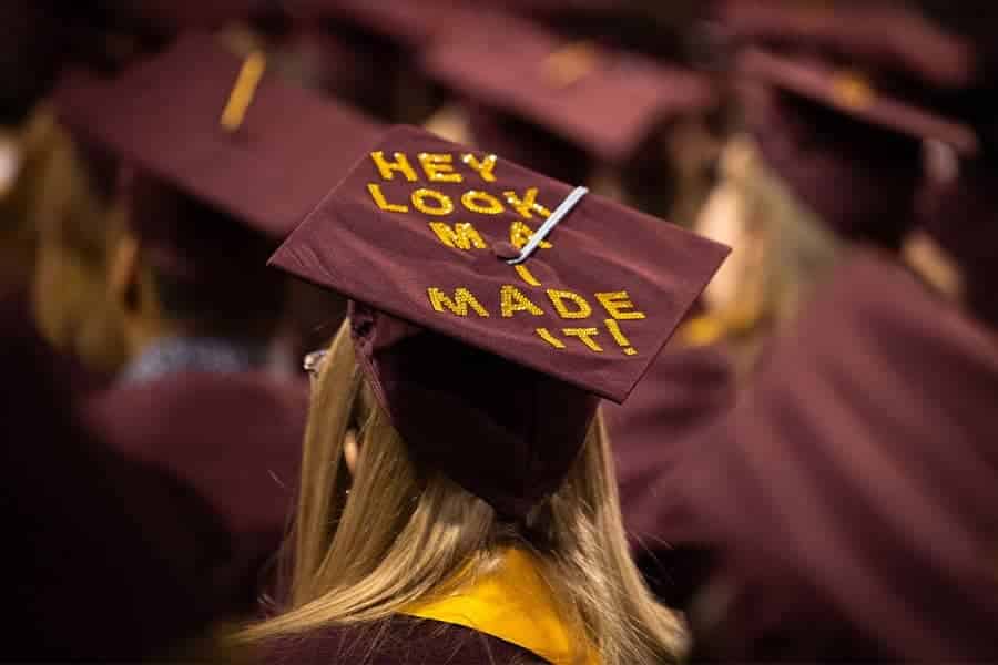 A woman wearing a maroon and gold graduation cap