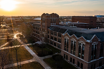 Warriner Hall stands majestically in the middle of CMU's campus on an early spring morning as the sun rises.