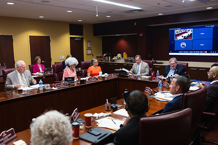 Members of the CMU Board of Trustees sit around a large conference table.
