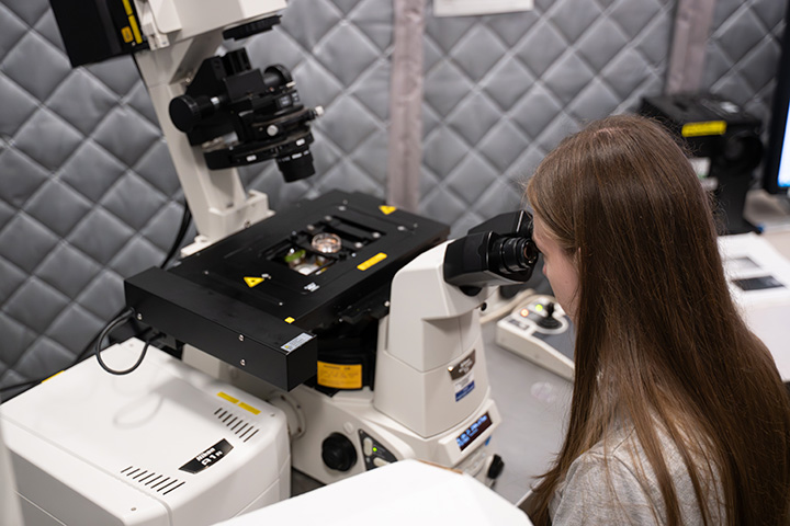 A woman looking through a microscope.