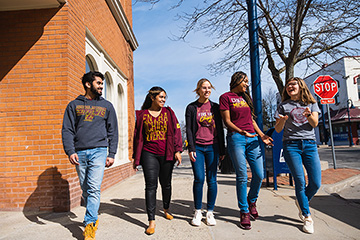 A group of CMU students walk down the sidewalk in downtown Mt. Pleasant.