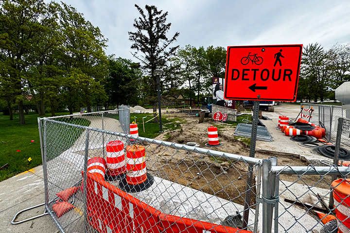 A fenced off area with a detour sign