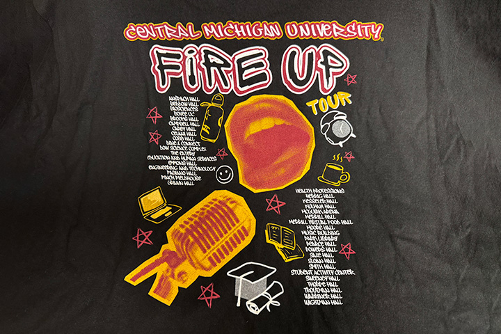 A concert-themed t-shirt design with the words Central Michigan University, Fire Up, Tour and images of a mouth and microphone.