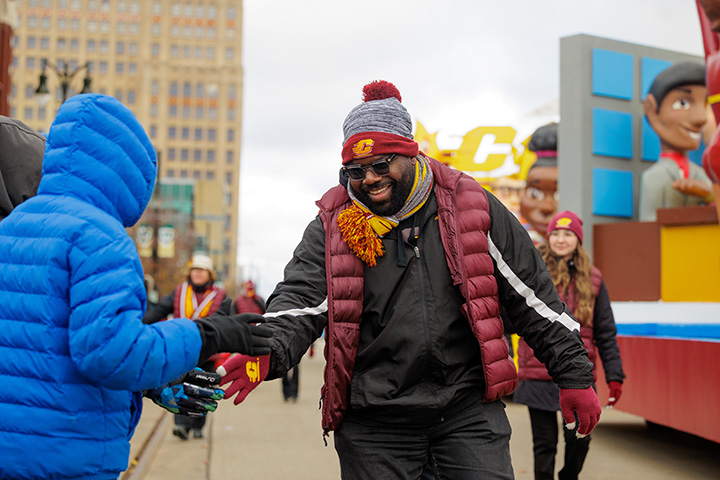 Lester Booker Jr. wears CMU clothing, walks in the parade giving high-fives to spectators