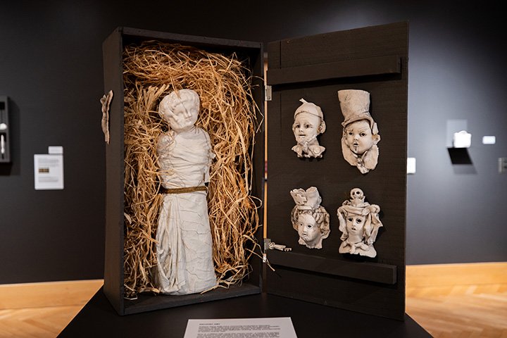 Four statues are displayed in a black box sitting on a table.