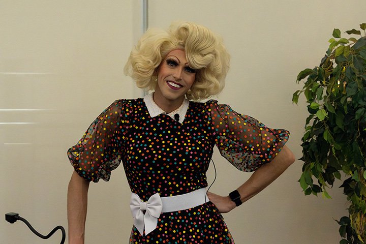 A drag queen wearing a blonde wig and sparkly dress.