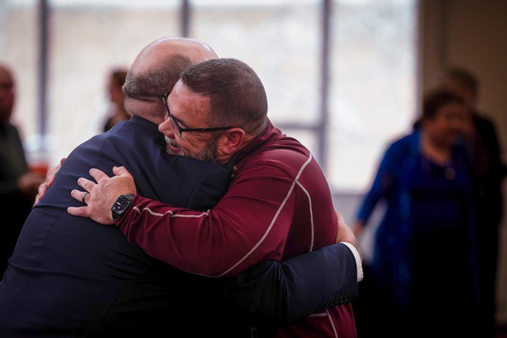 Two people embrace.