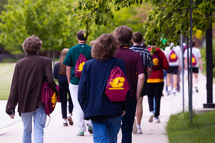 A group of people walking on a sidewalk.