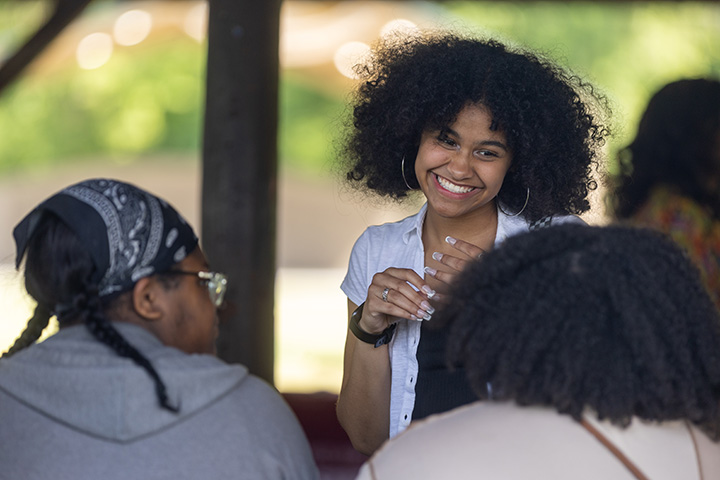 A woman smiling with a group of people.