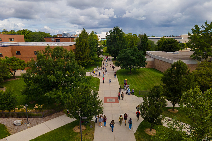 An aerial view of people walking on a sidewalk through CMU's campus