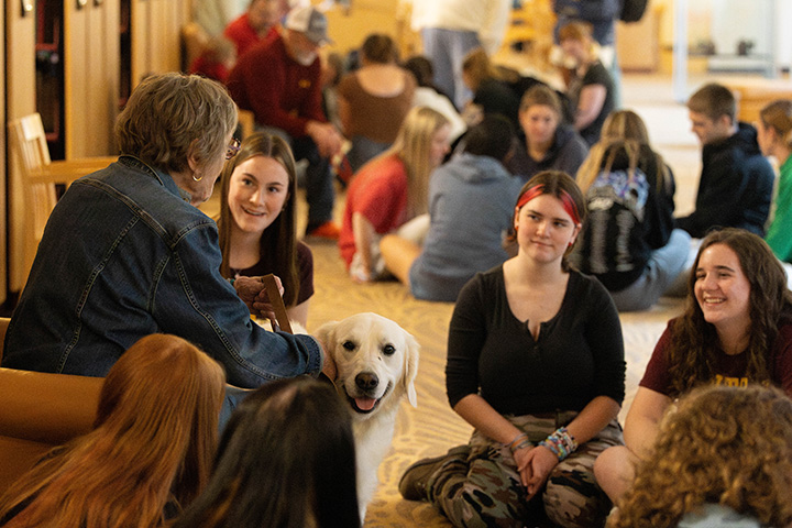 A group of people sitting on the floor with a dog