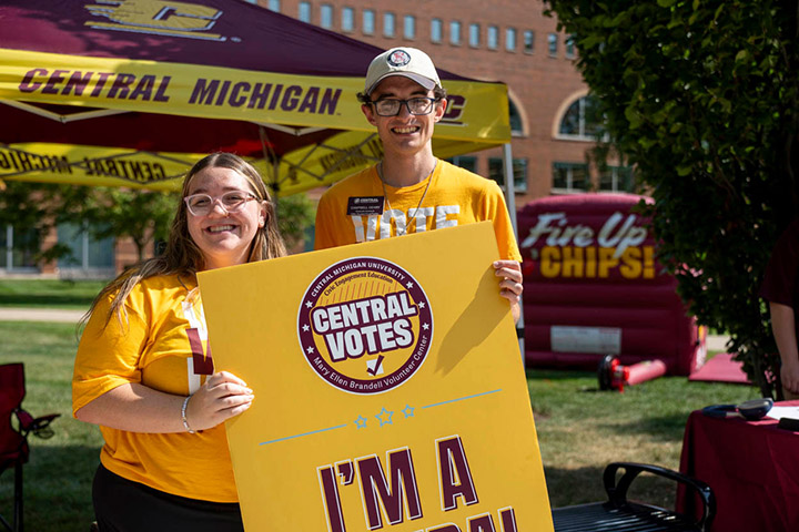 A man and woman holding a sign