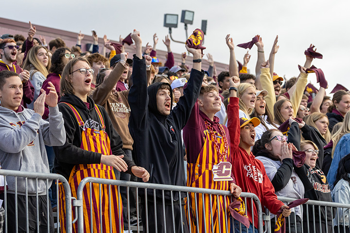 A group of CMU football fans cheering in the crowd