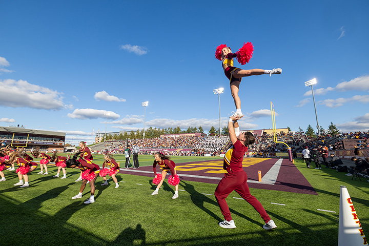 Cheerleaders performing on a football field