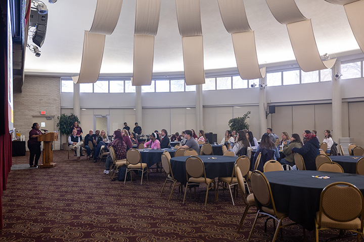 A group of people sitting at tables in a large room