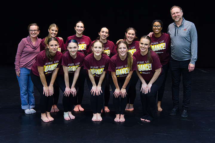 A group of 10 dance students and two faculty members posing for a photo