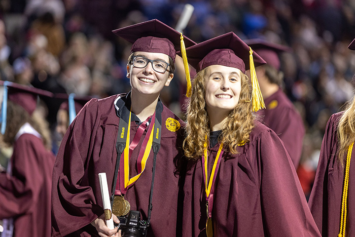 Two people in CMU graduation gowns and caps.