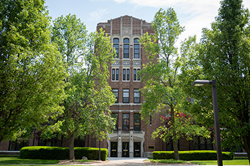 A tall brick building surrounded by trees