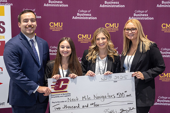 A group of people in professional attire holding a large novelty check