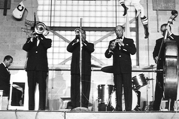 A black and white photo of a group of men playing musical instruments.