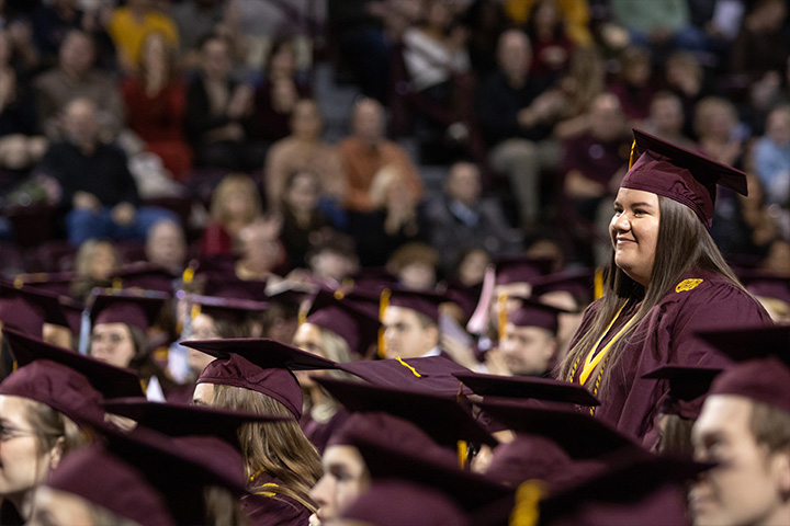 A group of people in graduation maroon caps and gowns