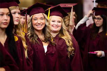 A group of women in graduation gowns and caps.