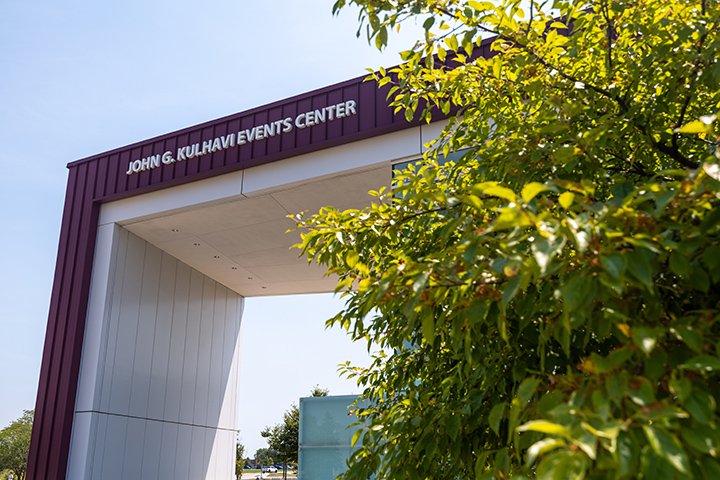 A maroon and white building with a sign that reads John G. Kulhavi Events Center