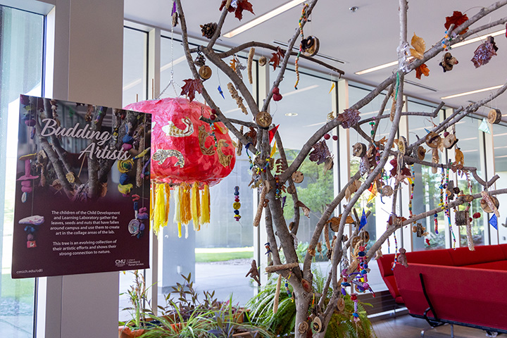 A small tree with a red lantern and other small items hanging from its branches.