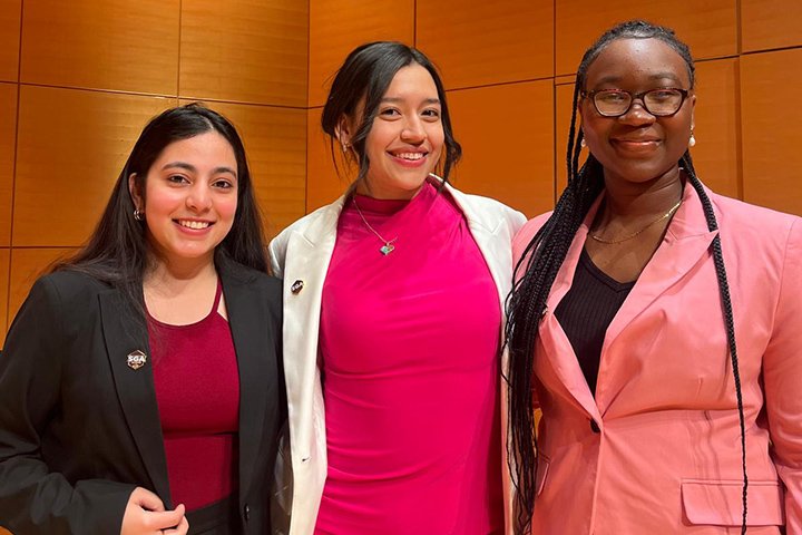 The three members of the CMU SGA executive board post for a photo. All three are dressed up, wearing blazers.