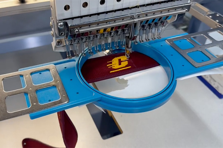 A hat being embroidered with the CMU logo