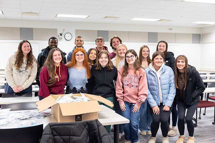 A group of people posing for a photo inside a classroom