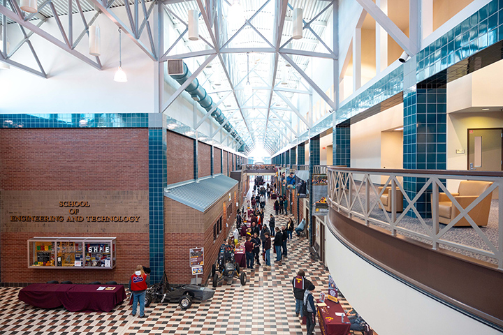A wide angle shot of the inside of the engineering building with group of people in the lower-level hallway