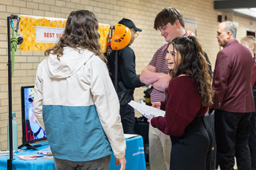 A group of people standing around a table at a career fair.