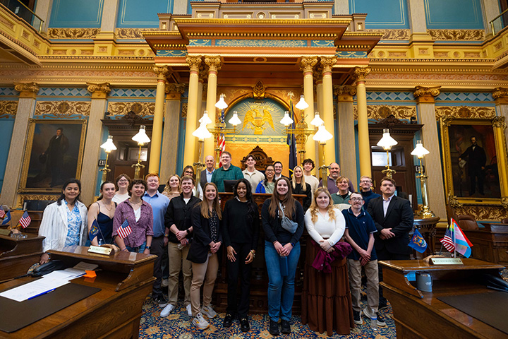 A group of students pose for a photo inside the Michigan State Capitol Building