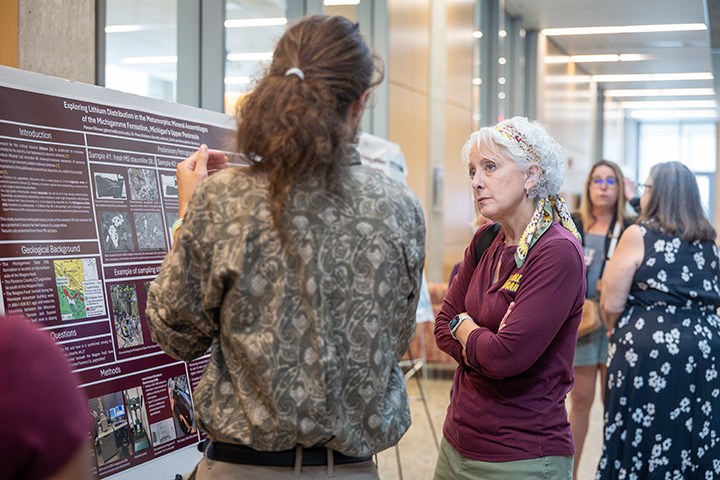 Provost Lancaster speaks with a student about their research