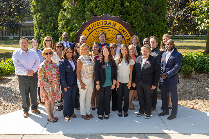 A group photo of the 2026 Doctorate of Health Administration Cohort in front of the CMU seal